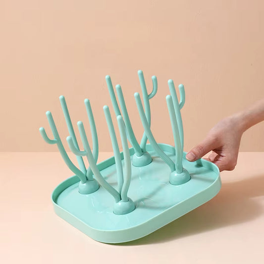 Arbre à Biberon Pratique et Démontable sur fond beige tenu par une main