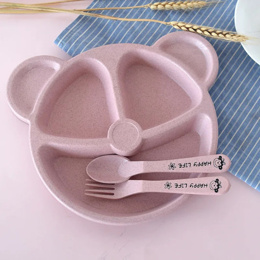 Assiette Bébé Compartiment à Design de Visage avec Couverts sur fond rose et bleu